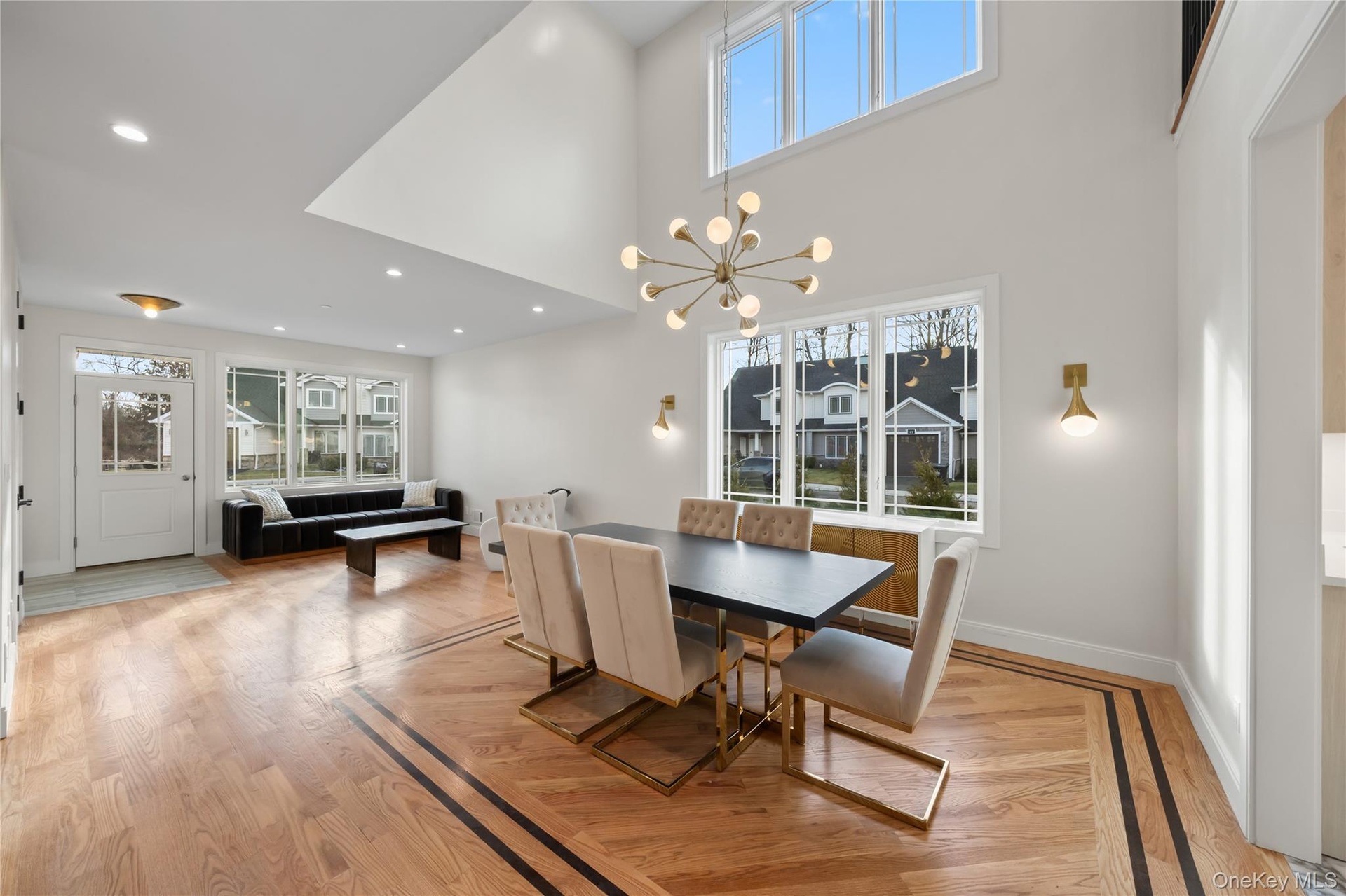 Dining area featuring a chandelier, light wood finished floors, a towering ceiling, and recessed lighting