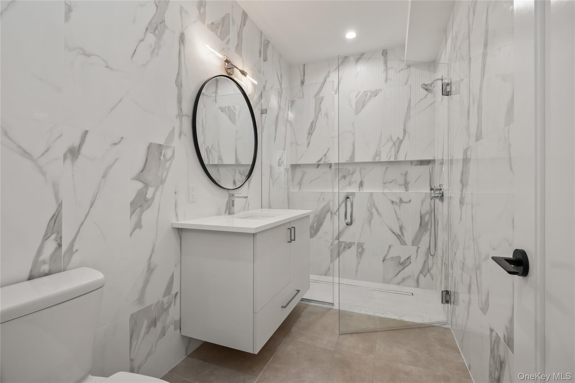 Bathroom with a marble finish shower and vanity