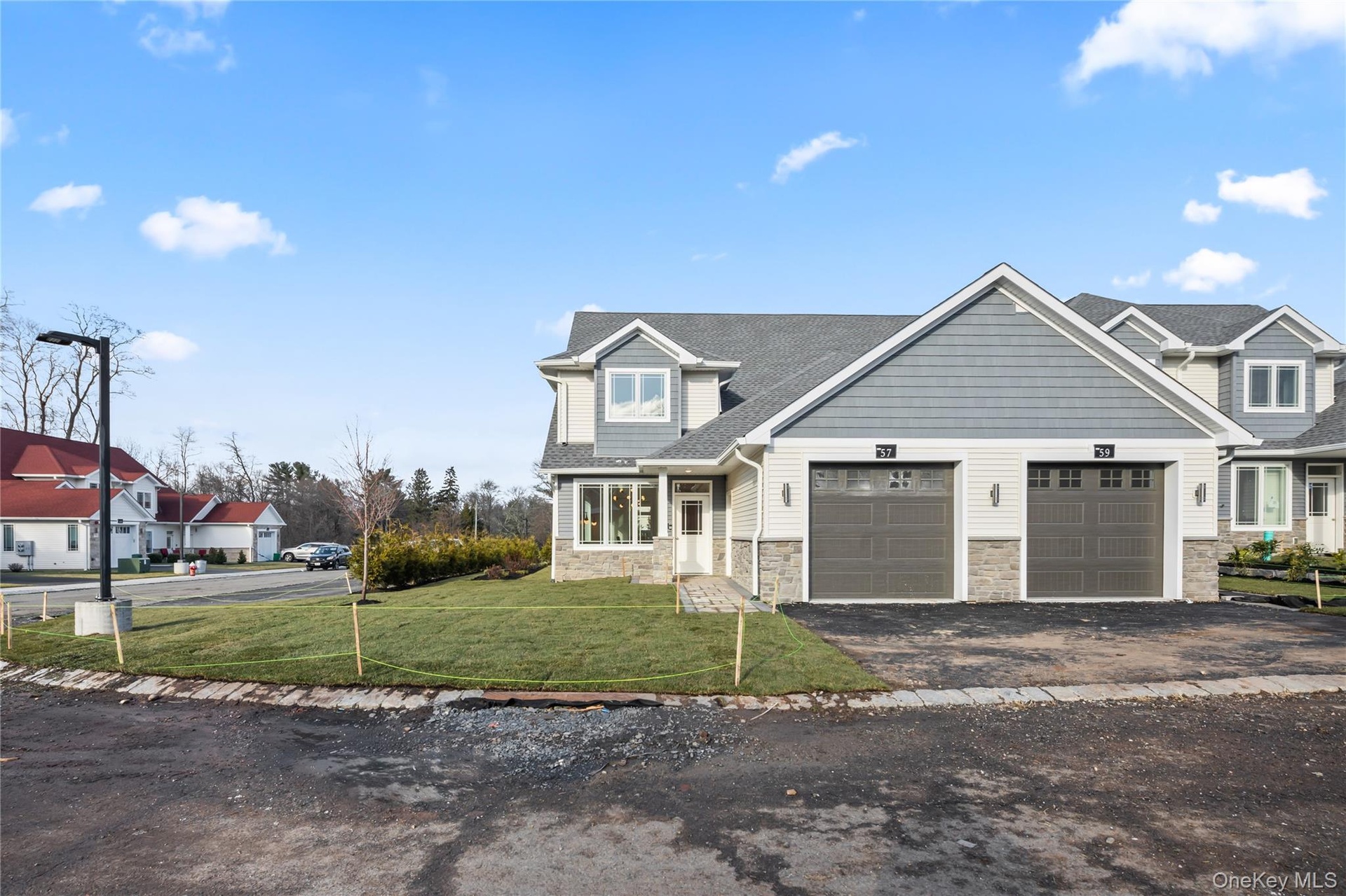 Craftsman inspired home featuring stone siding, asphalt driveway, a front yard, and a garage
