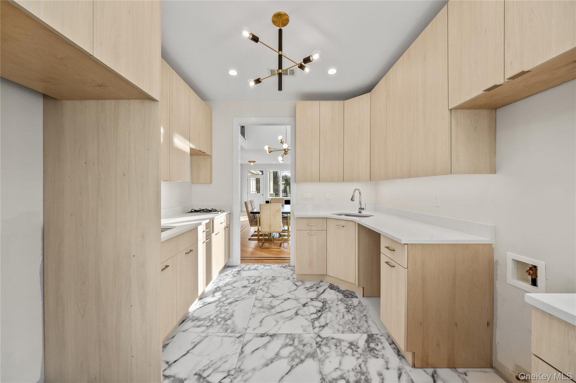 Kitchen featuring light brown cabinetry, modern cabinets, light marble finish flooring, a chandelier, and recessed lighting