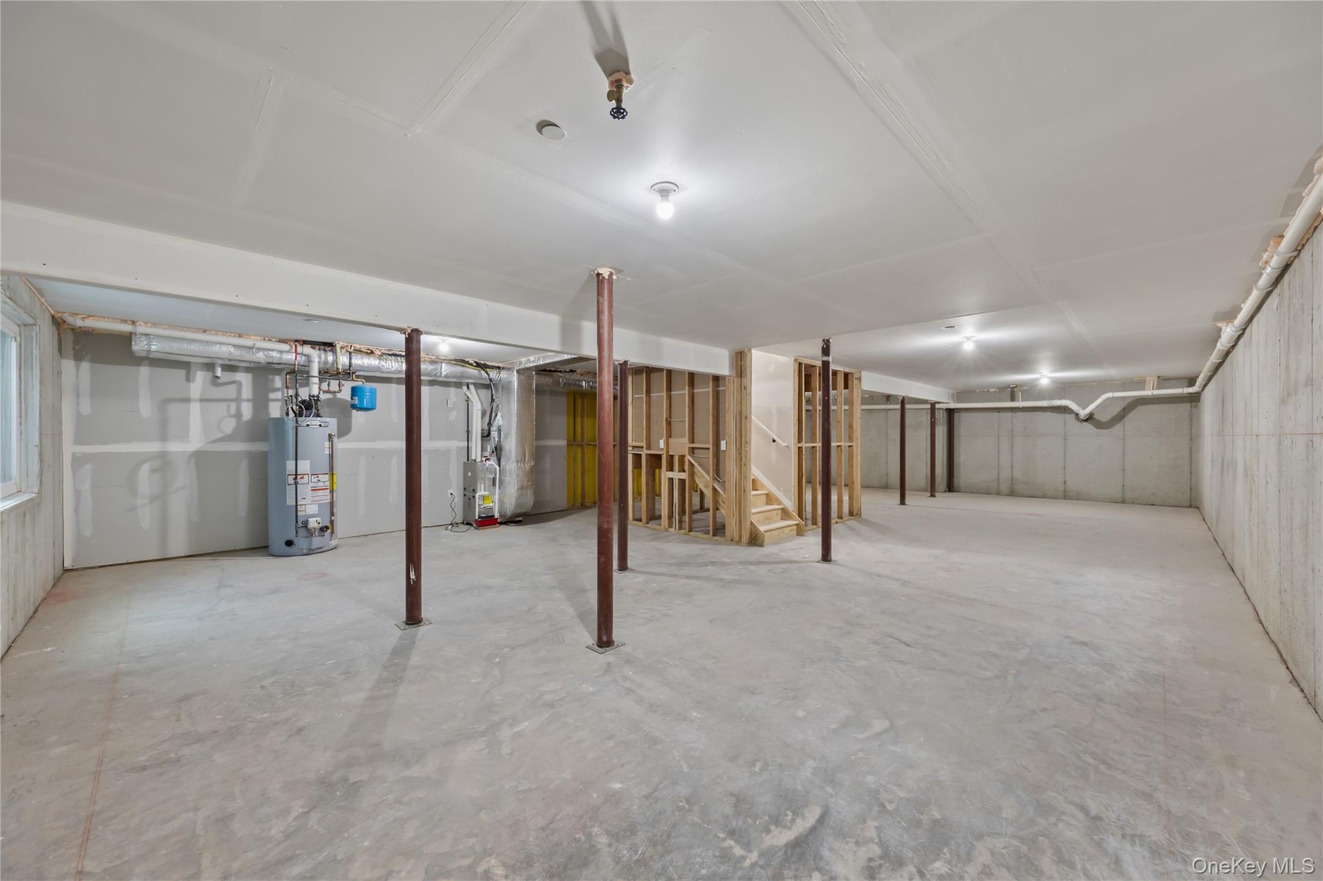 Unfinished below grade area with stairs, water heater, and heating unit