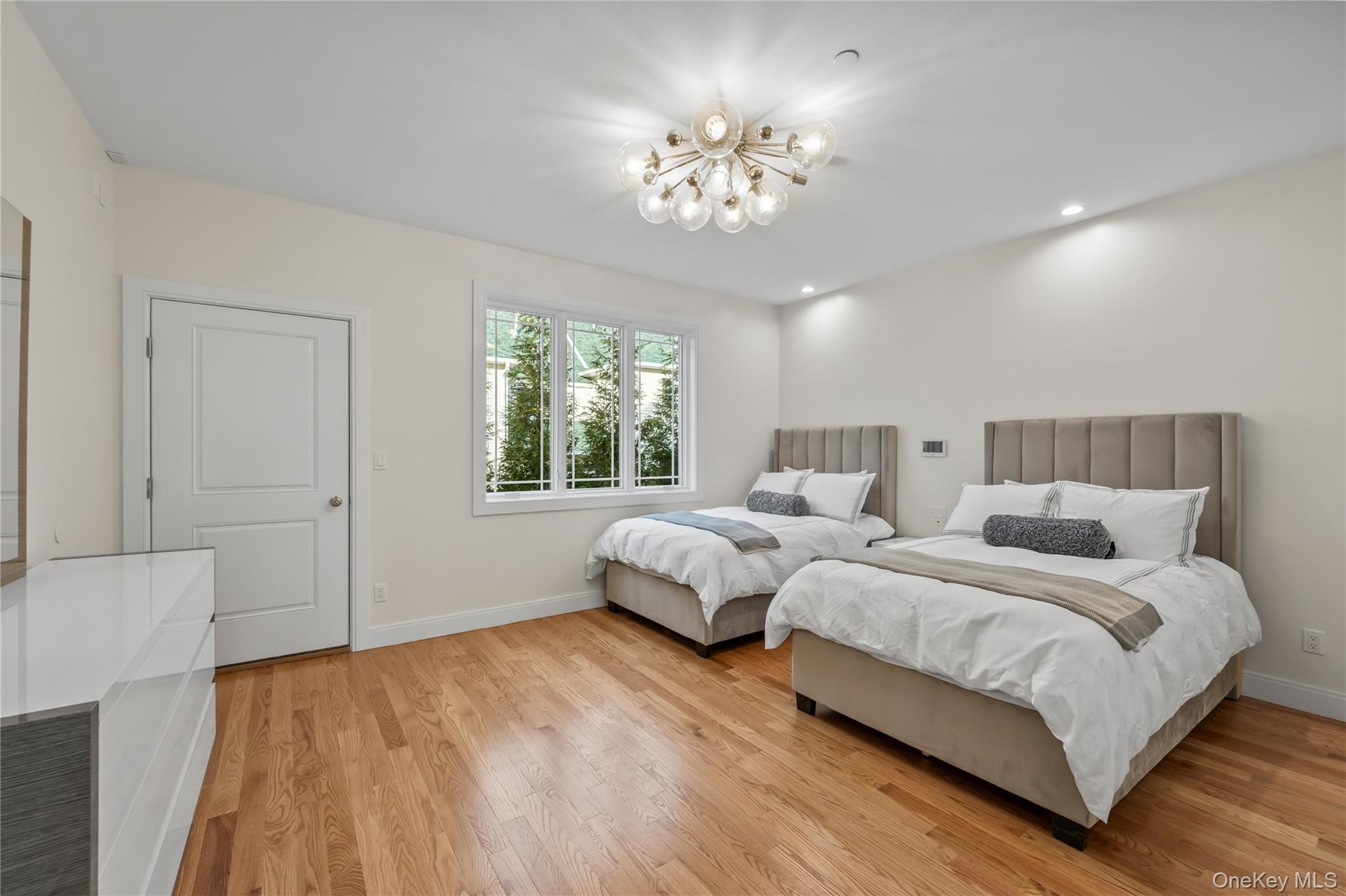 Bedroom with light wood finished floors, a chandelier, and recessed lighting