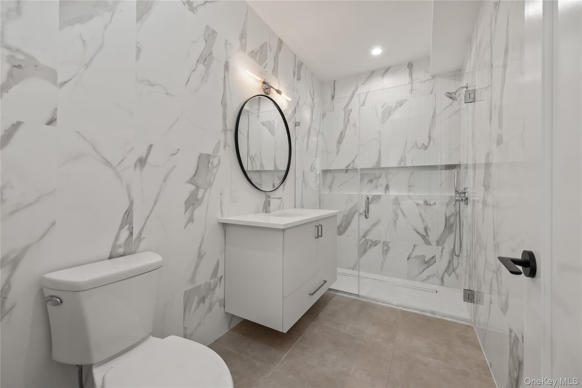 Bathroom with vanity and a marble finish shower