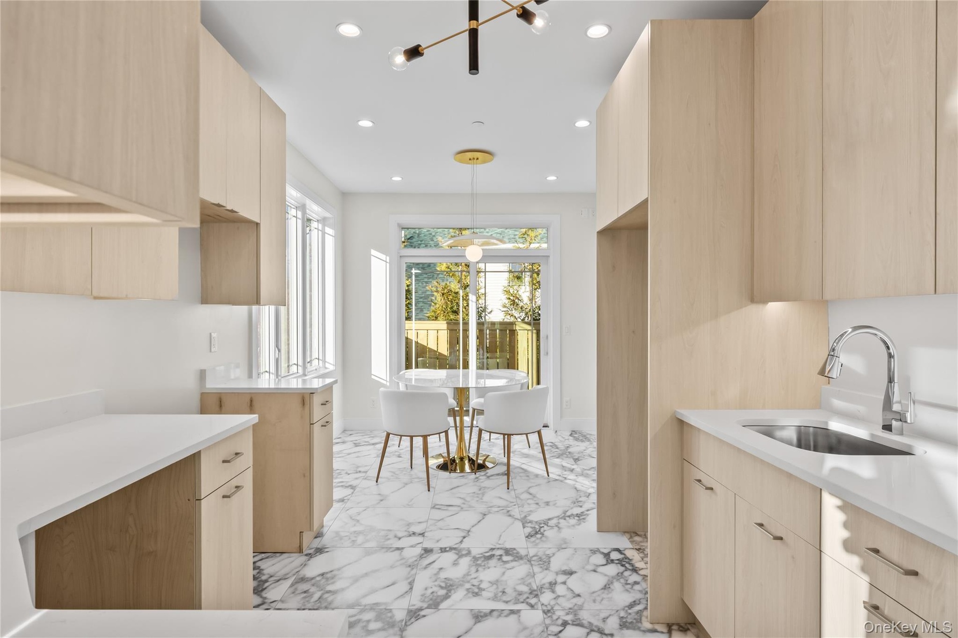 Kitchen featuring light brown cabinetry, modern cabinets, recessed lighting, pendant lighting, and light stone countertops
