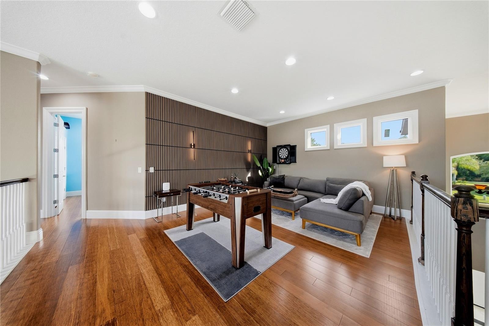 Upstairs with game room with its built in wood wall feature is striking and sure to gather guests