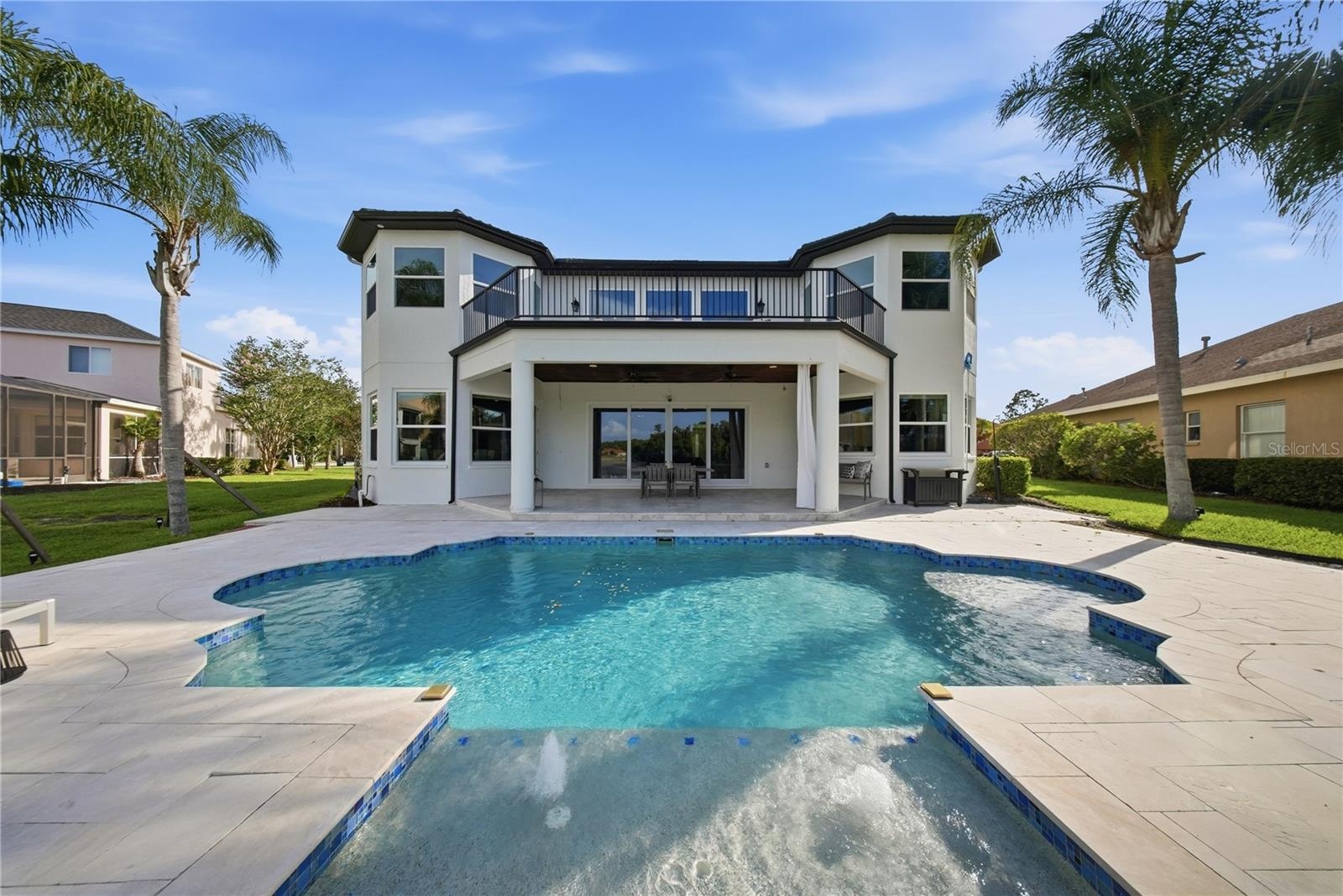 The pool is heated and includes a sun shelf with umbrella stand