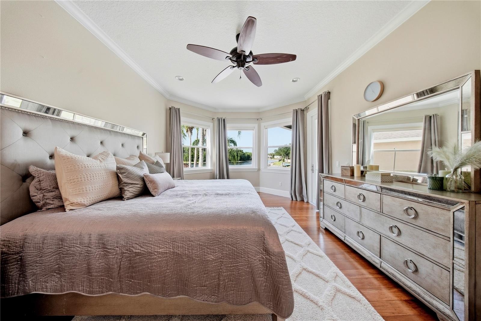 Primary bedroom has panoramic lake views and a private access to the lanai/pool deck