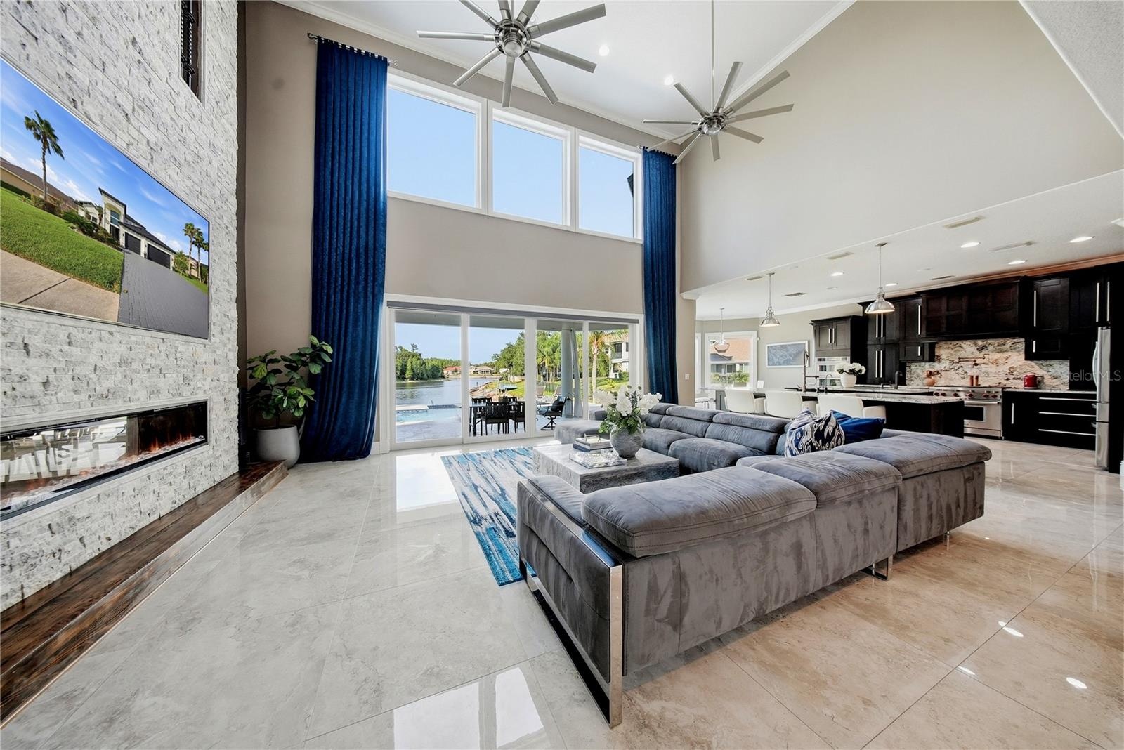 Family room with floor to ceiling stone fireplace with porcelain tile floors