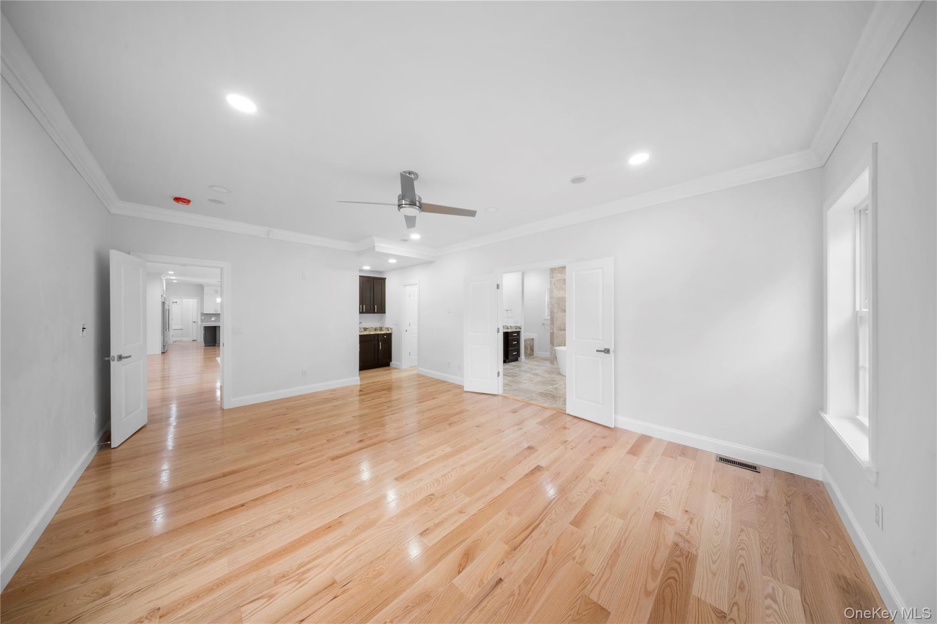 Unfurnished living room with ornamental molding, light wood-style flooring, recessed lighting, and a ceiling fan