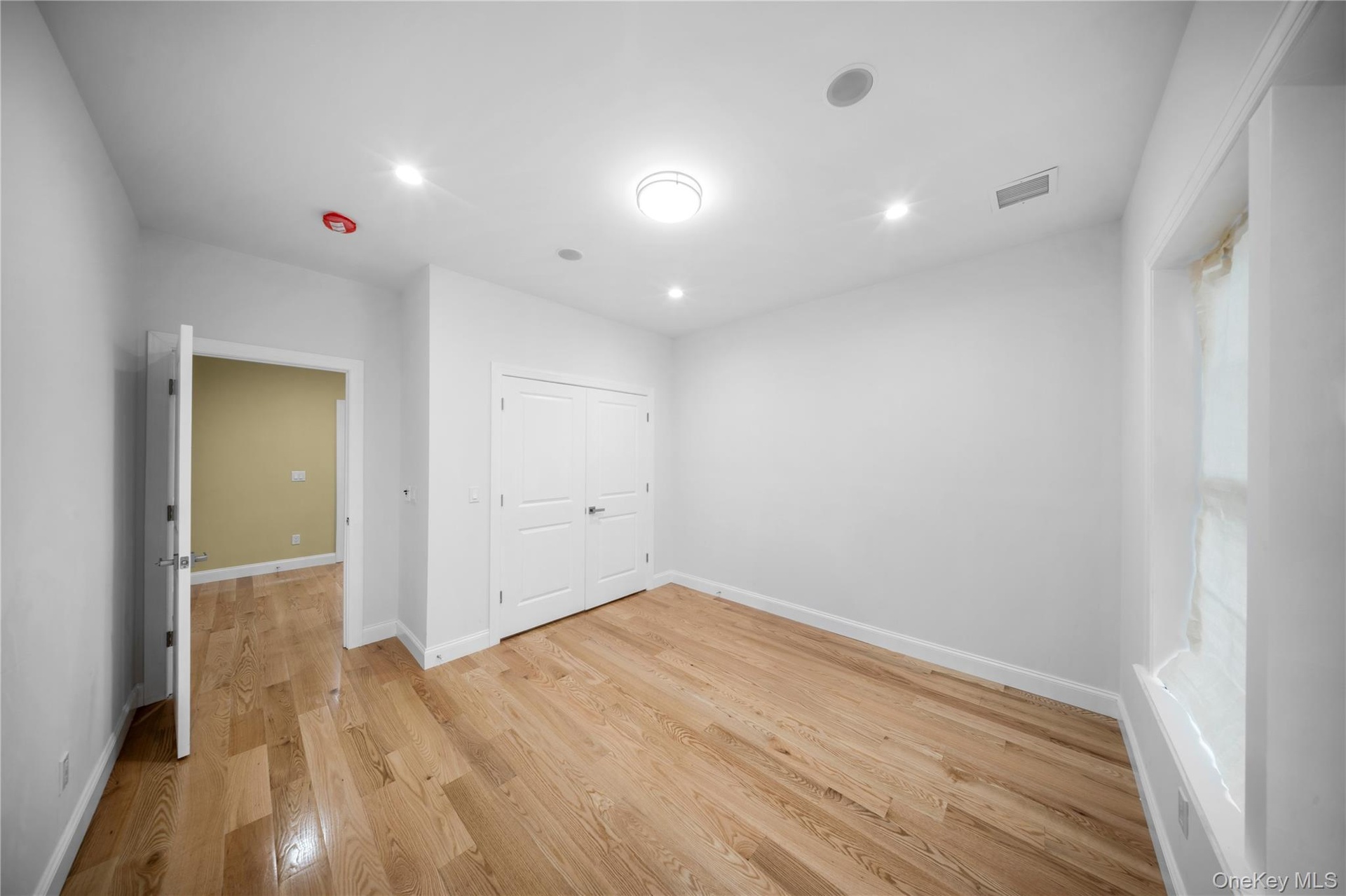 Unfurnished bedroom with light wood-type flooring, recessed lighting, and a closet