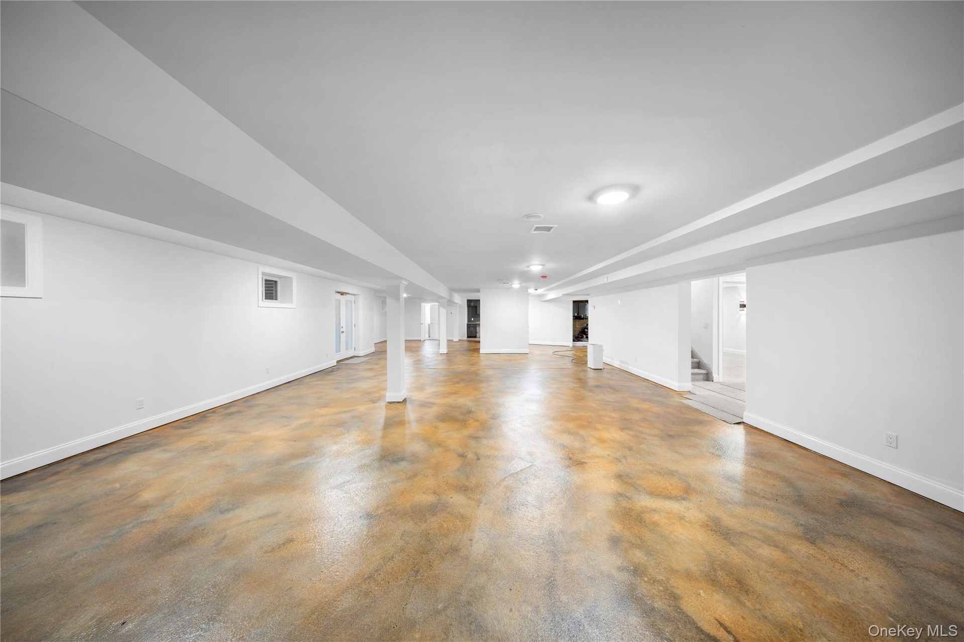 Finished basement with baseboards and stairway