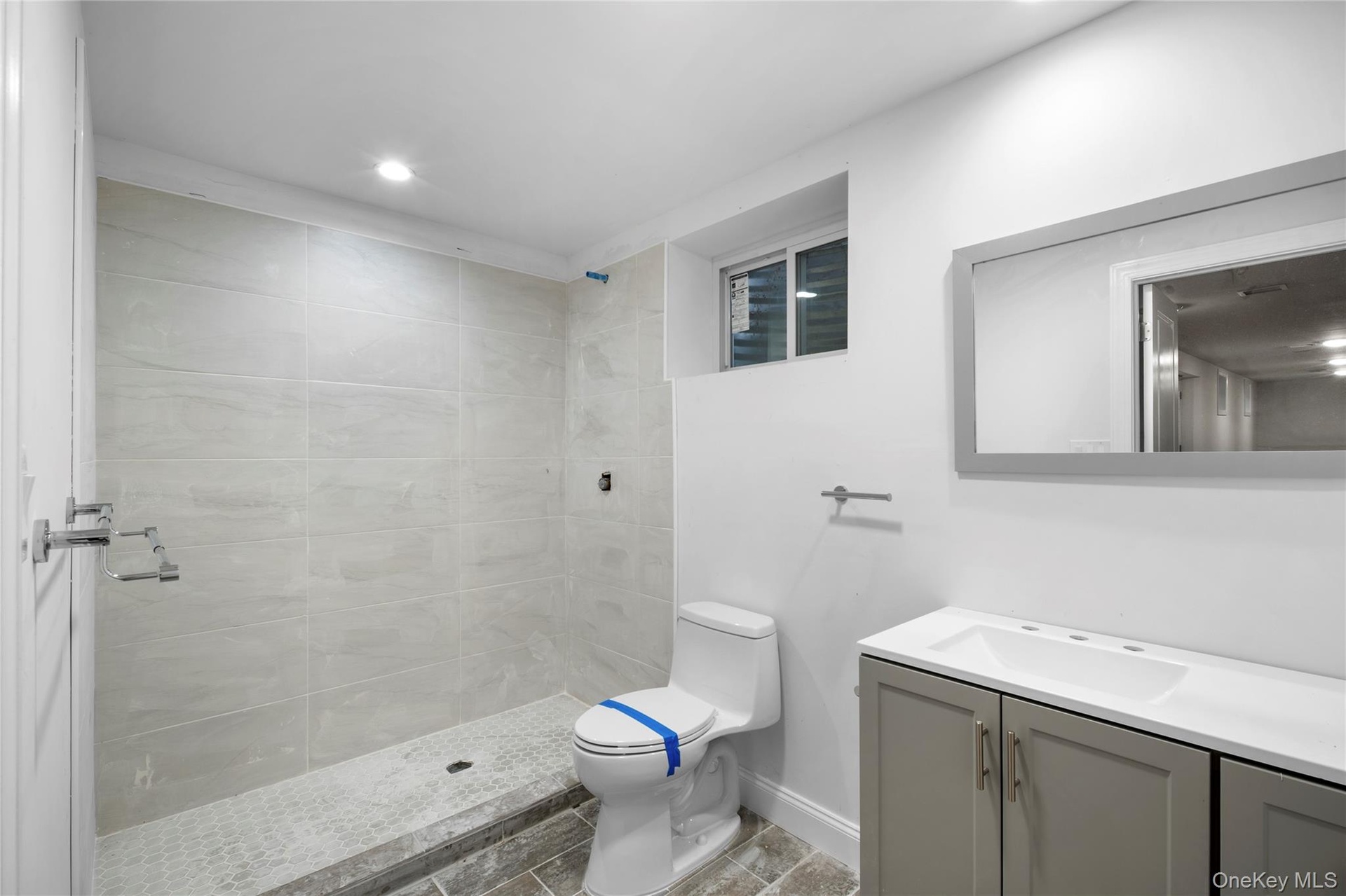 Bathroom with a shower stall, vanity, and recessed lighting
