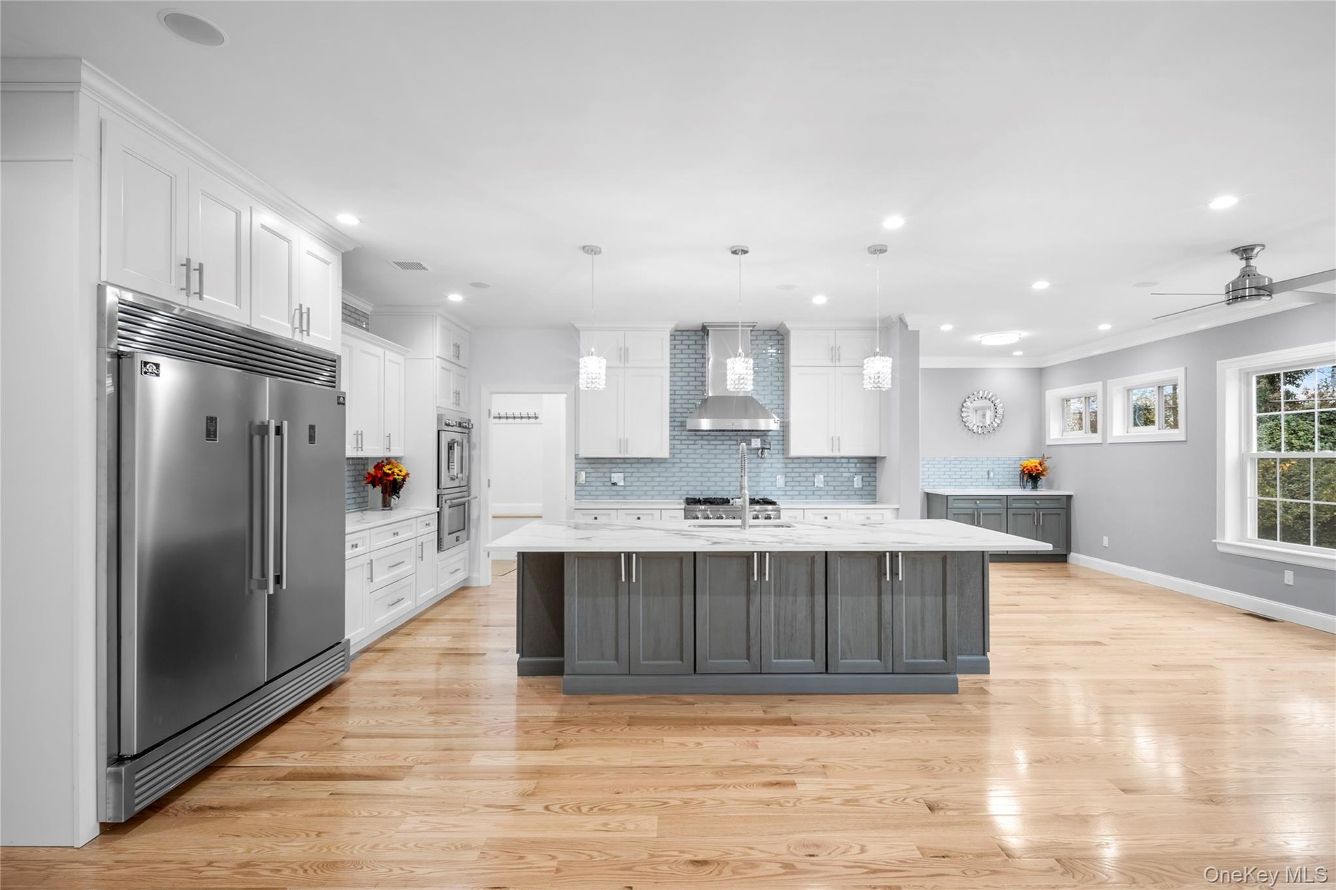 Kitchen with white cabinets, backsplash, stainless steel appliances, recessed lighting, and ornamental molding