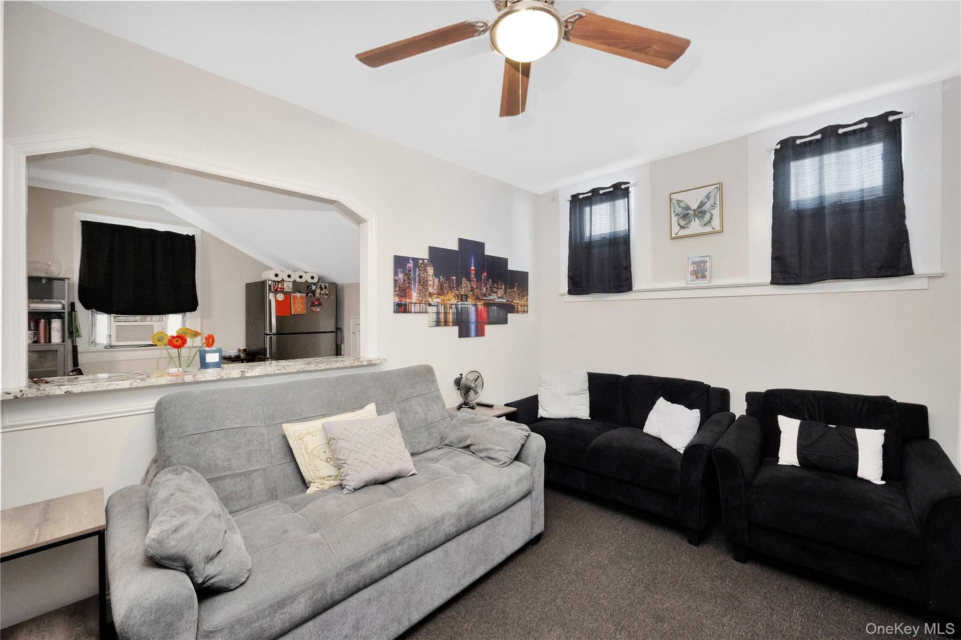 Living area with a ceiling fan, cooling unit, and carpet floors