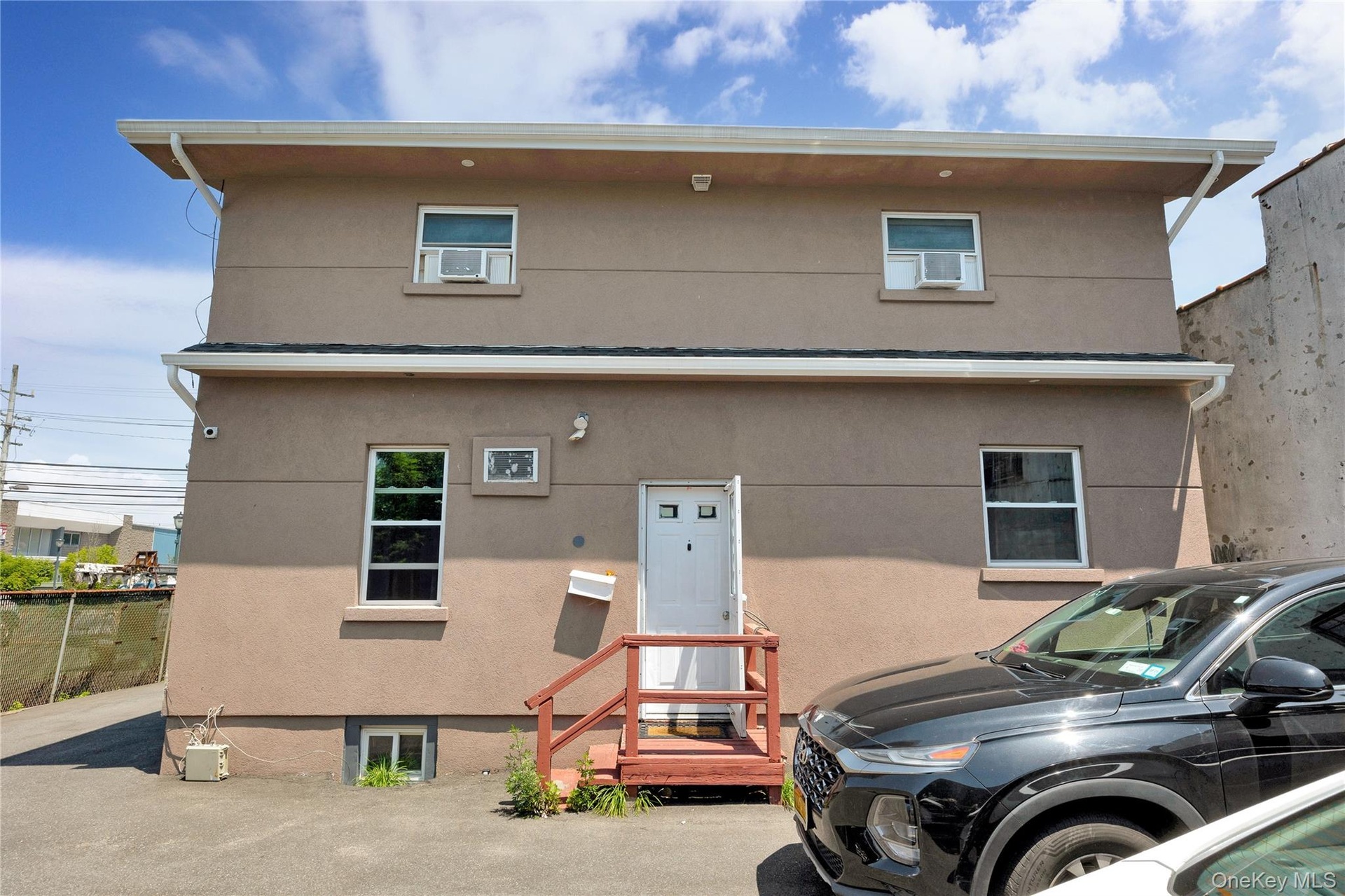 View of front of property featuring stucco siding and cooling unit