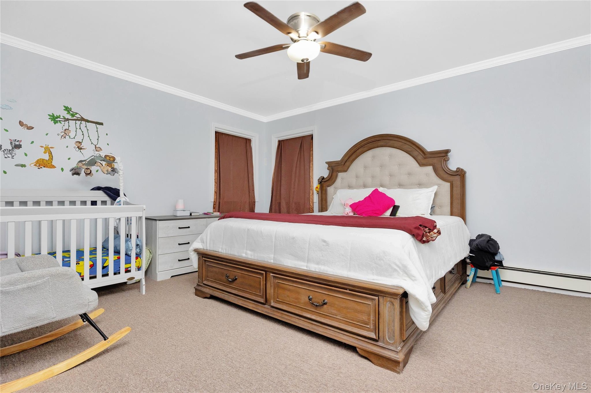 Bedroom with crown molding, light colored carpet, and ceiling fan