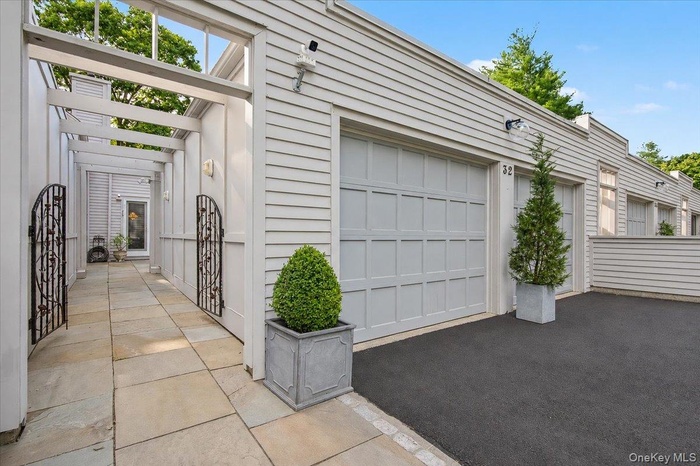 Two-car garage and entry to 32 Beechwood through iron gate.