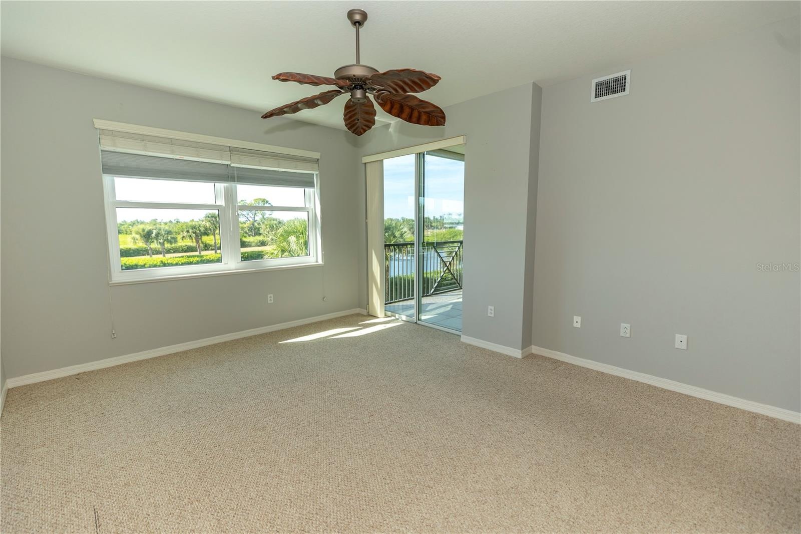 Primary bedroom with slider to lanai and hurricane shutters