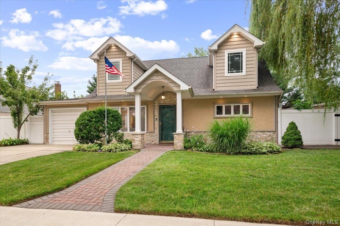 Beautifully Updated and Expanded Cape with Oversized Portico, Stone, Stucco, Vinyl Siding and newer architectural shingle roof.
