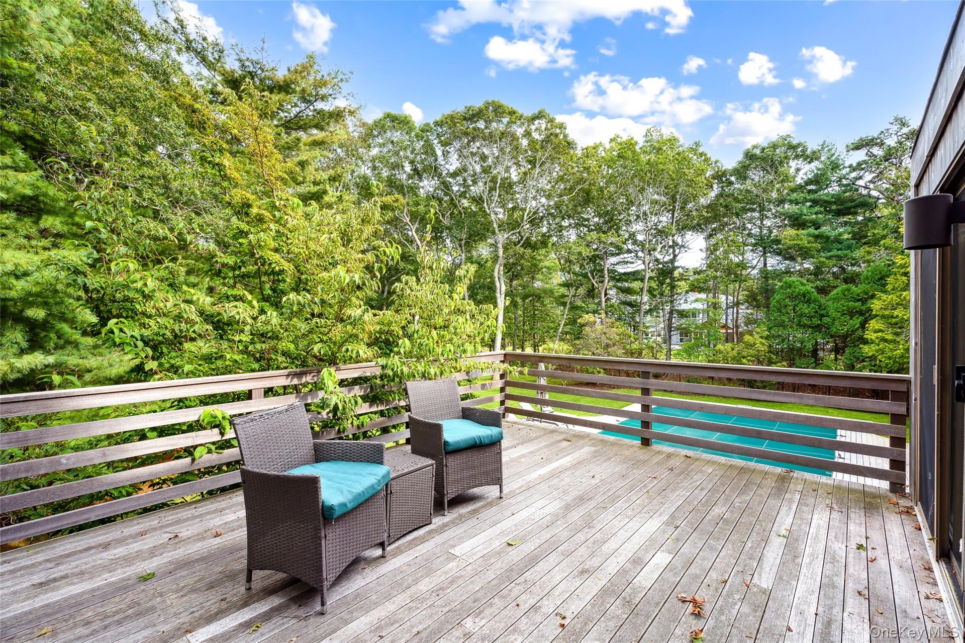 Wooden terrace featuring view of wooded area
