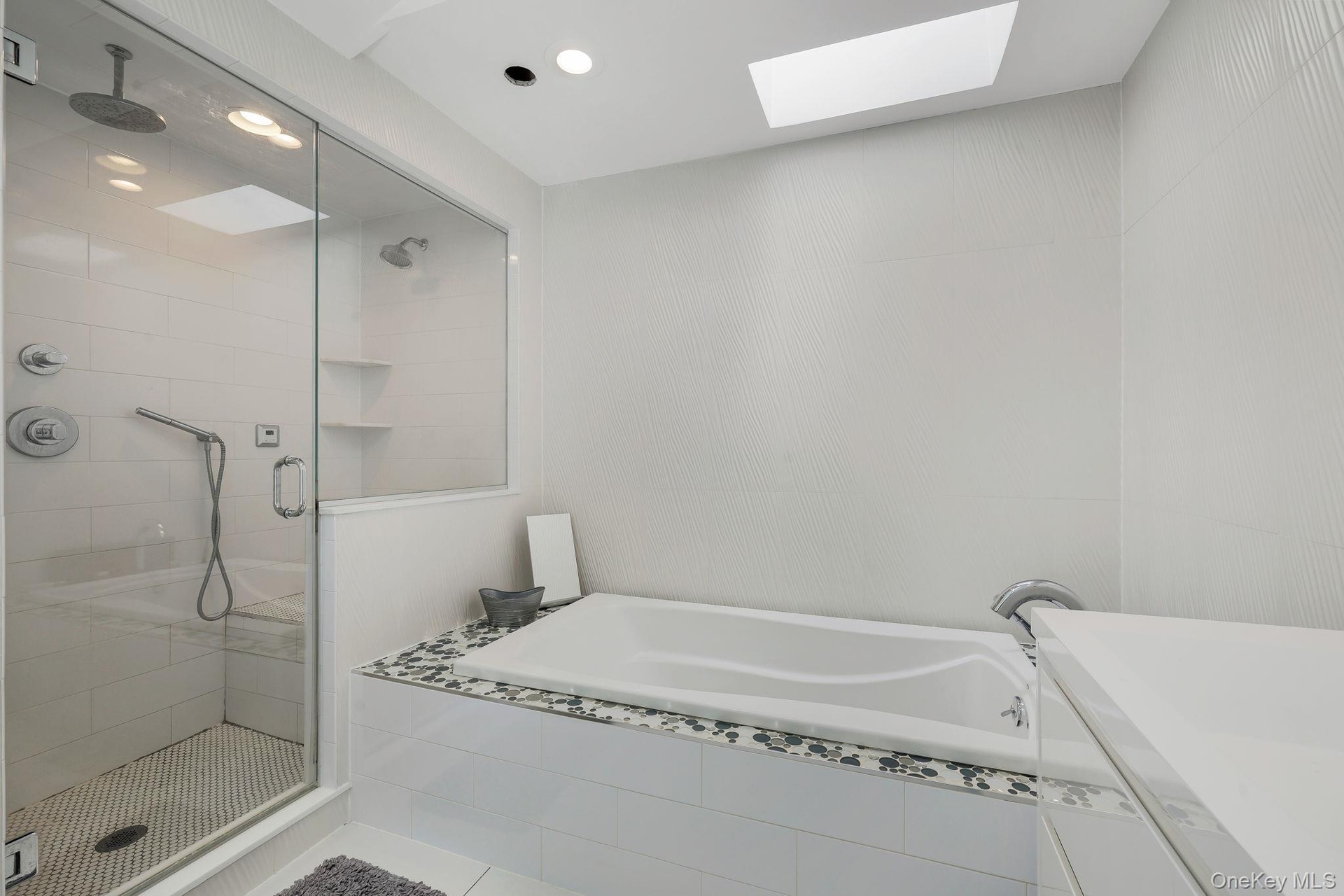 Primary En Suite Walk in Shower with ceiling mounted rain shower head, built in steam unit and whirlpool soaking tub