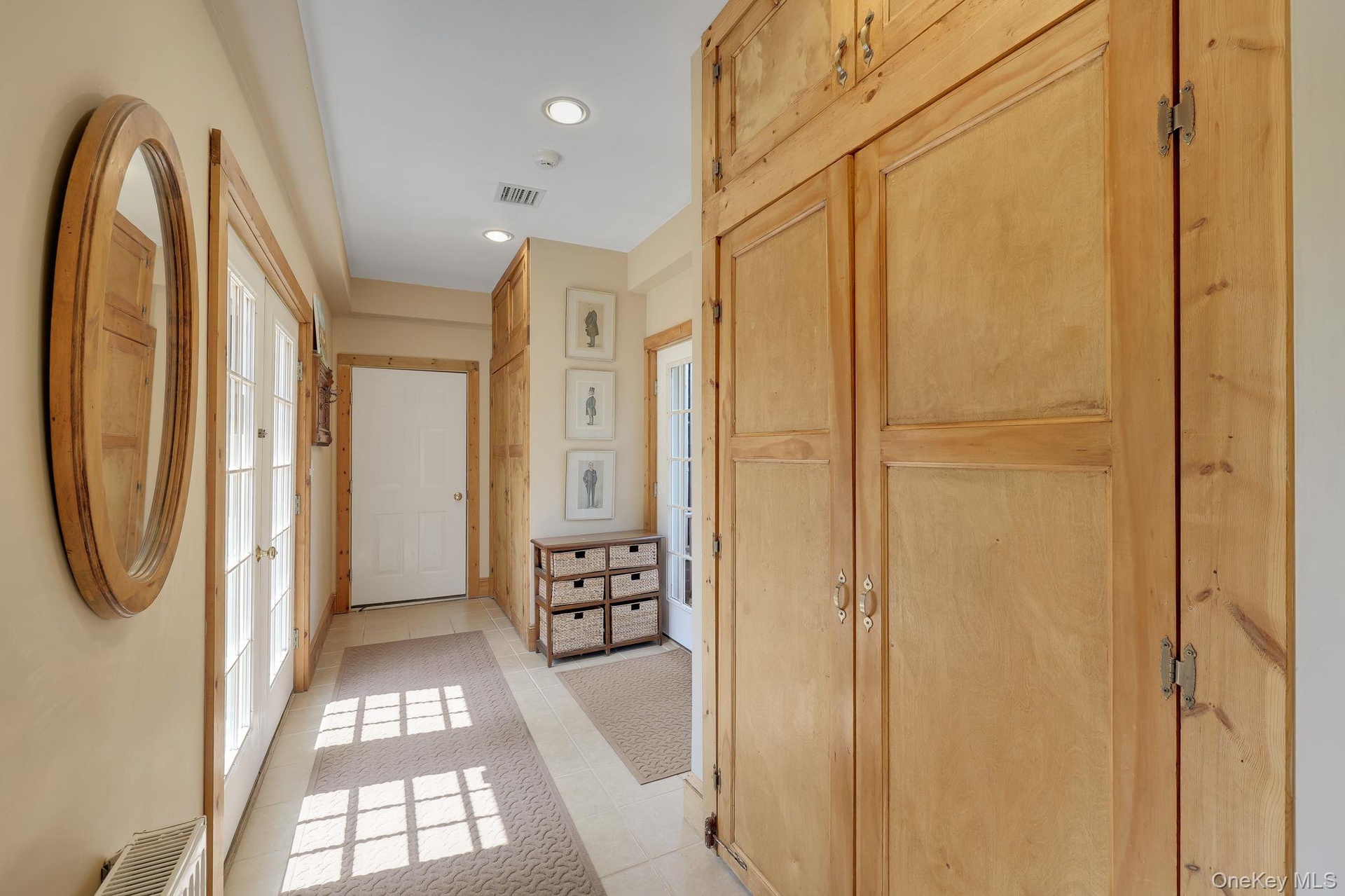 Foyer Hallway with extensive built-in wooden cabinetry, recessed lighting, and tile flooring.