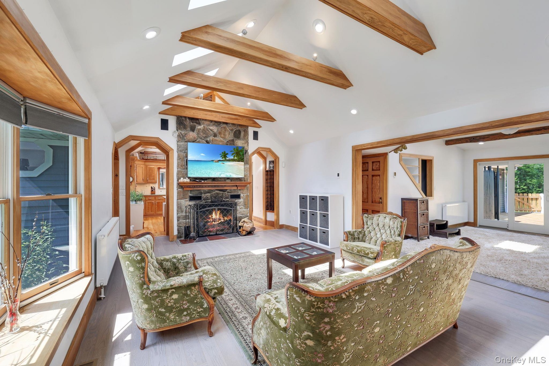 Living Room with vaulted ceilings with exposed wood beams, skylights, and recessed lighting. Open to the Family Room