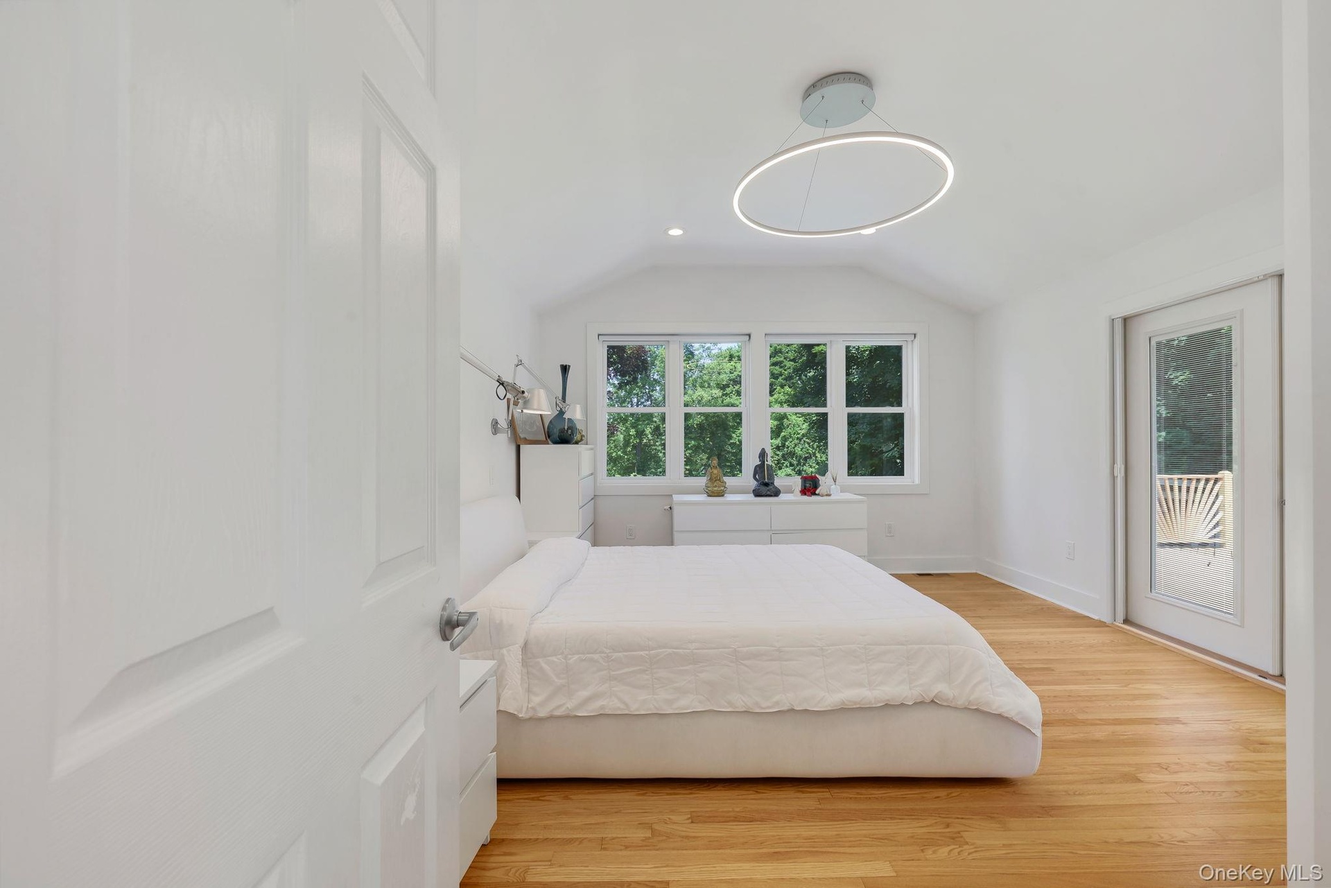 Primary Bedroom with hardwood floors and French doors leading to private deck with Hot Tub and outdoor shower