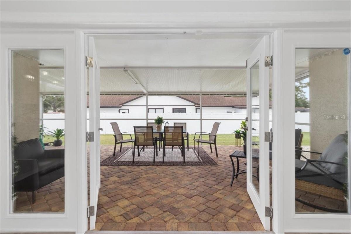 The French doors invite you to a fully enclosed paver patio, offering a versatile space for entertaining, dining, or simply enjoying the Florida lifes