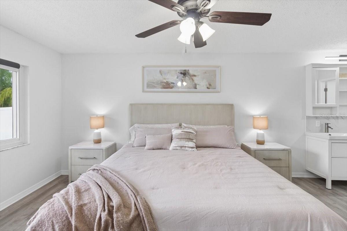 Escape to the spacious primary suite, complete with a beautifully updated en-suite bathroom featuring dual vanities, a stylish walk-in shower, and ele