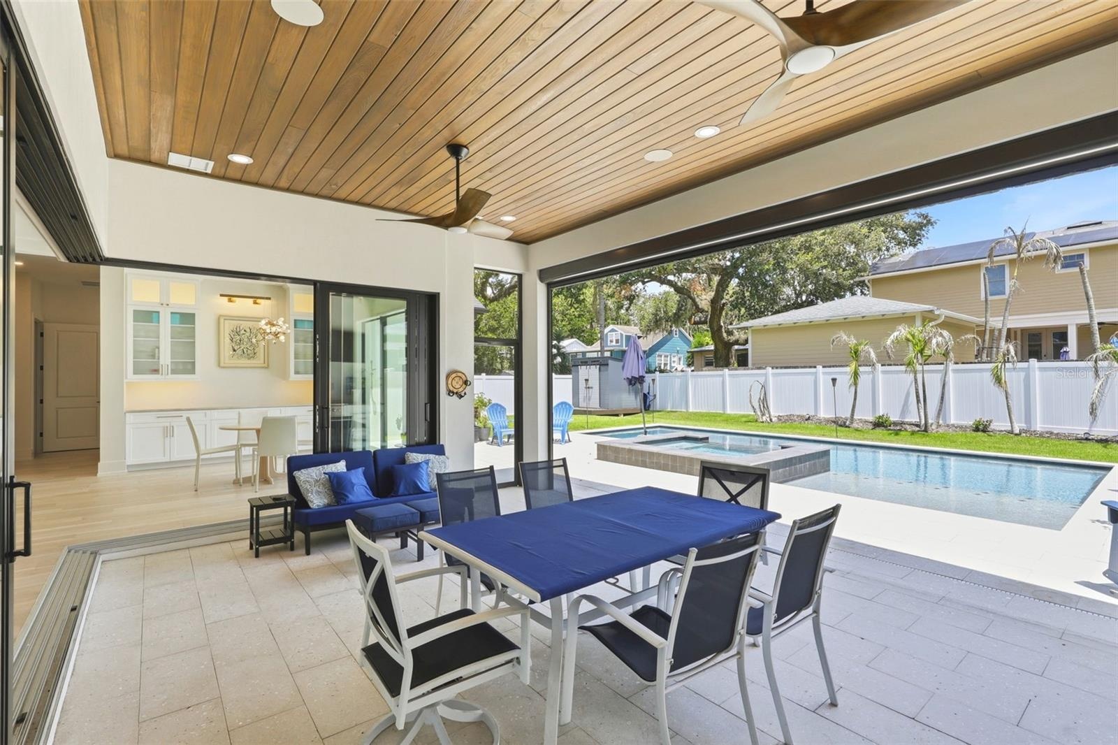 Lanai area with doors open to the living area and retractable screen open to the pool