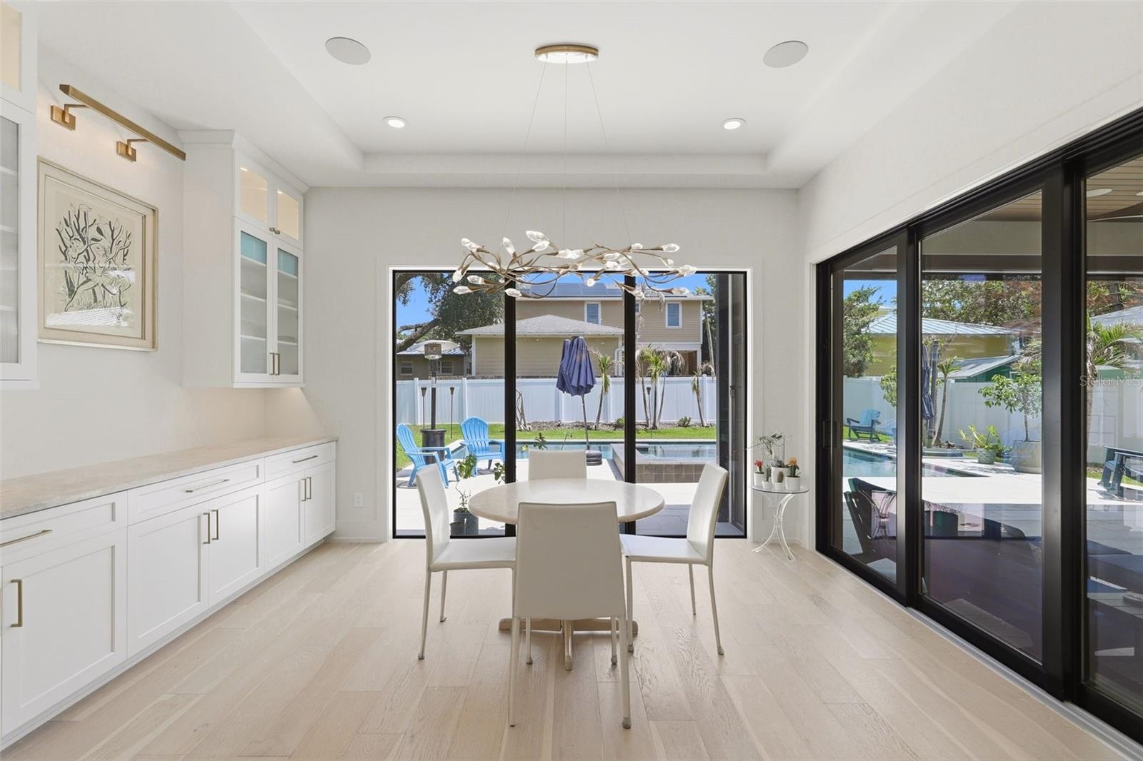Dining area with custom cabinetry and designer lighting