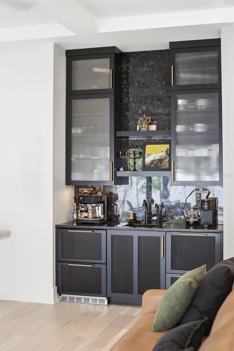 Wet bar includes 24" Thermador refrigerator and 24" Fisher & Paykel single door dishwasher