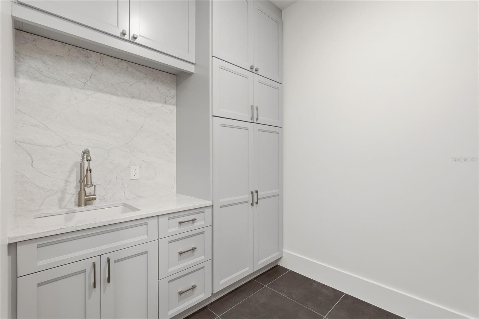 Upstairs laundry room with custom cabinets & utility sink
