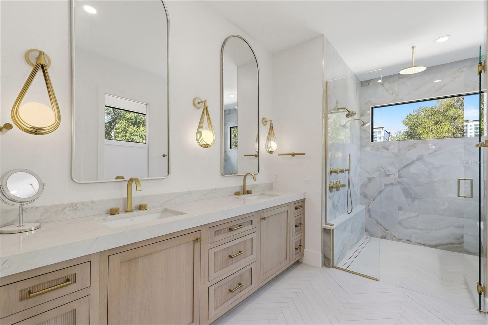 Primary bathroom with dual sinks, custom cabinets and designer lighting