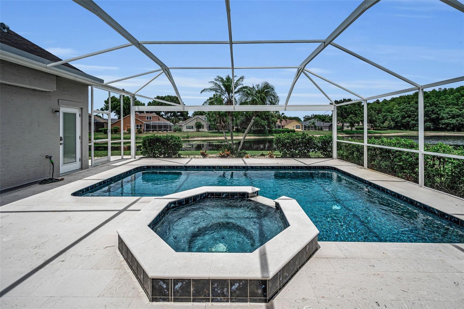 View of spa & pool and custom panoramic pool screen