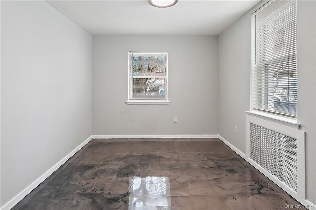 Room featuring a contemporary metallic epoxy floor, neutral painted walls, and white baseboards