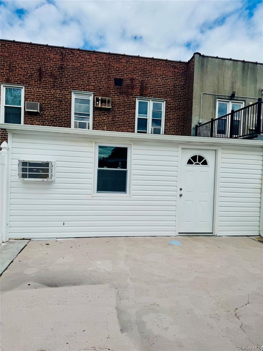 Rear view of property featuring a patio and brick siding