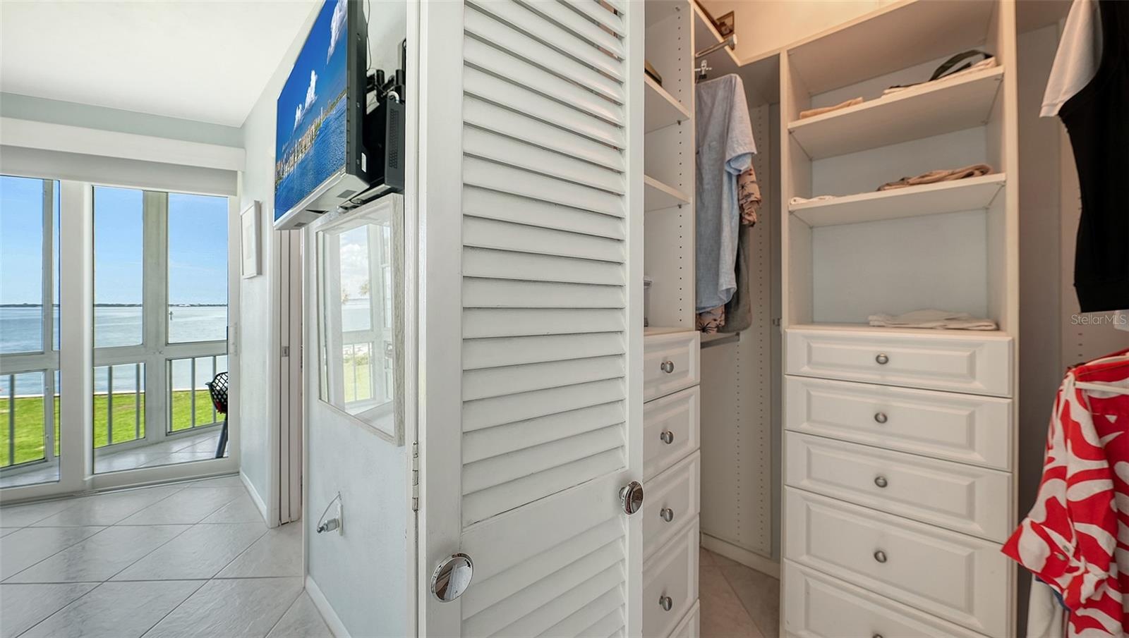A walk-in closet with custom cabinetry in the primary suite
