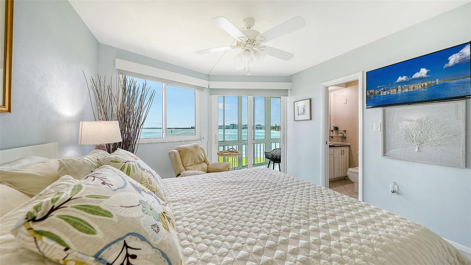 The primary suite offers an en suite bathroom and sliding door access to the enclosed lanai