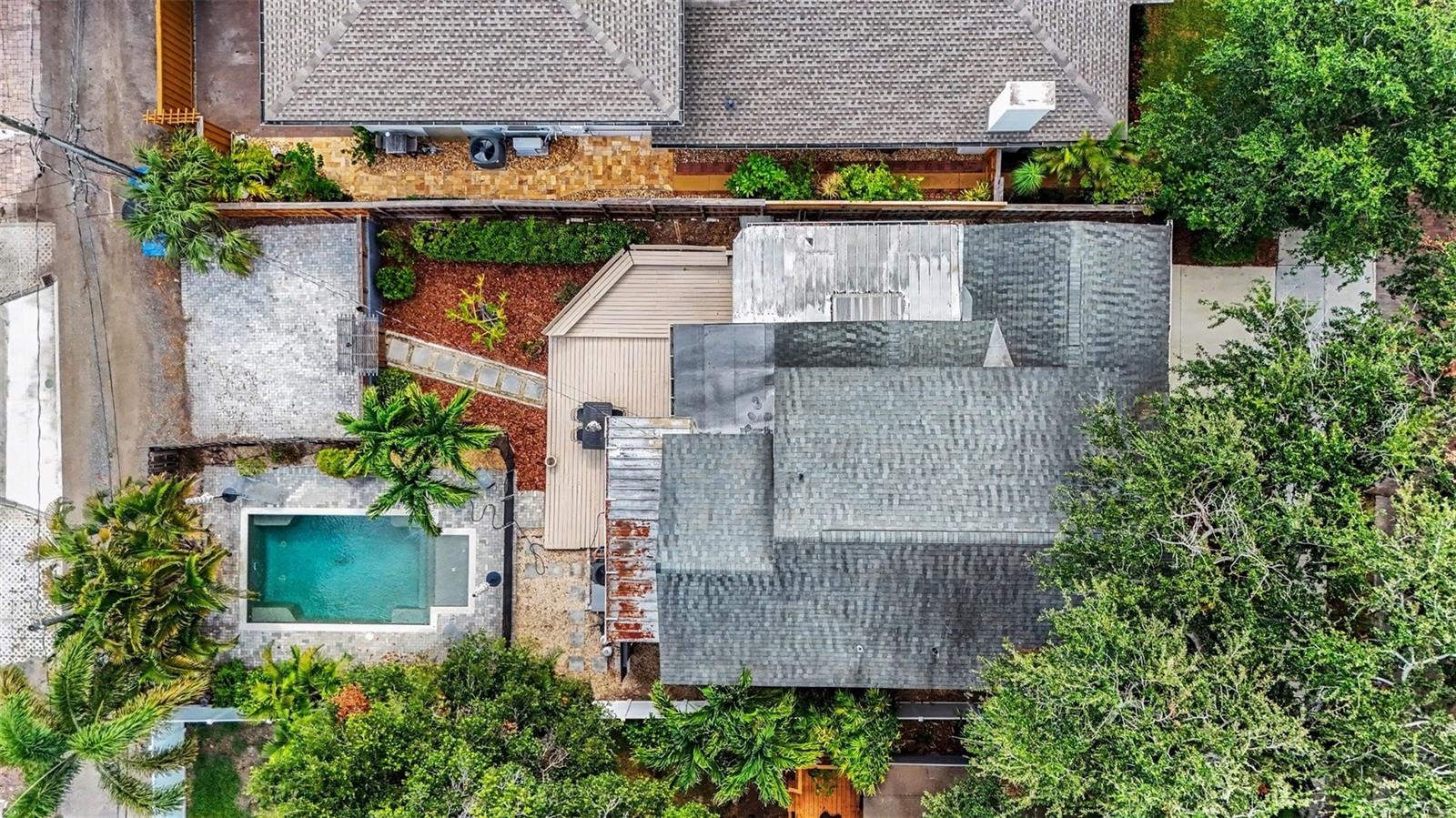 An overhead view shows the home’s layout, pool, deck, mature landscaping, and rear parking area.