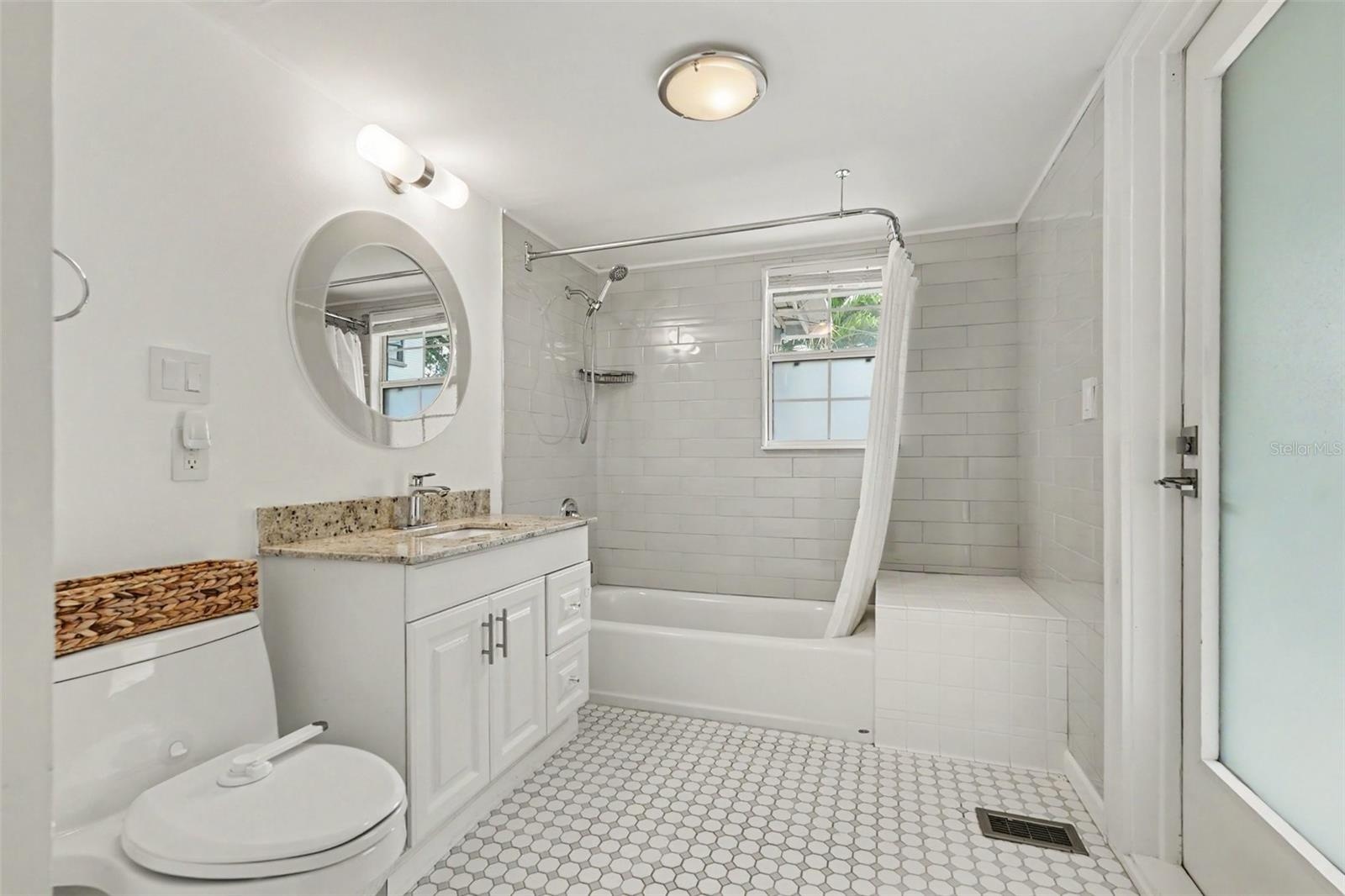 The updated downstairs bath pairs crisp finishes with a layout designed for comfortable everyday living.