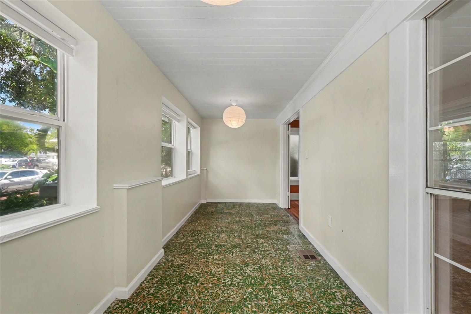 Imagine slow mornings with coffee in this light-filled porch, surrounded by windows and views of the tree-lined neighborhood.