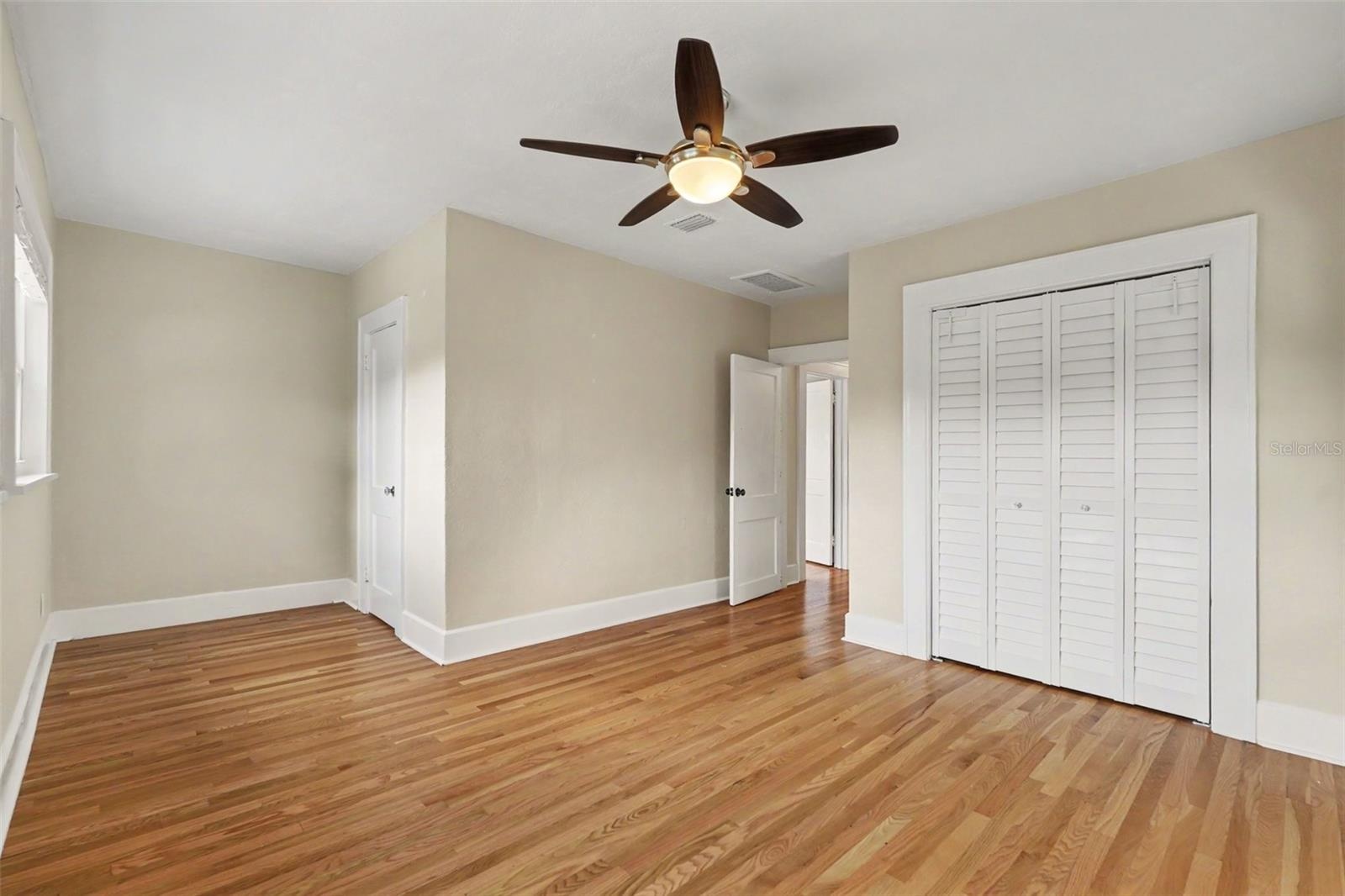 The fourth bedroom continues the home’s blend of character and comfort, with warm wood floors and generous closet space.