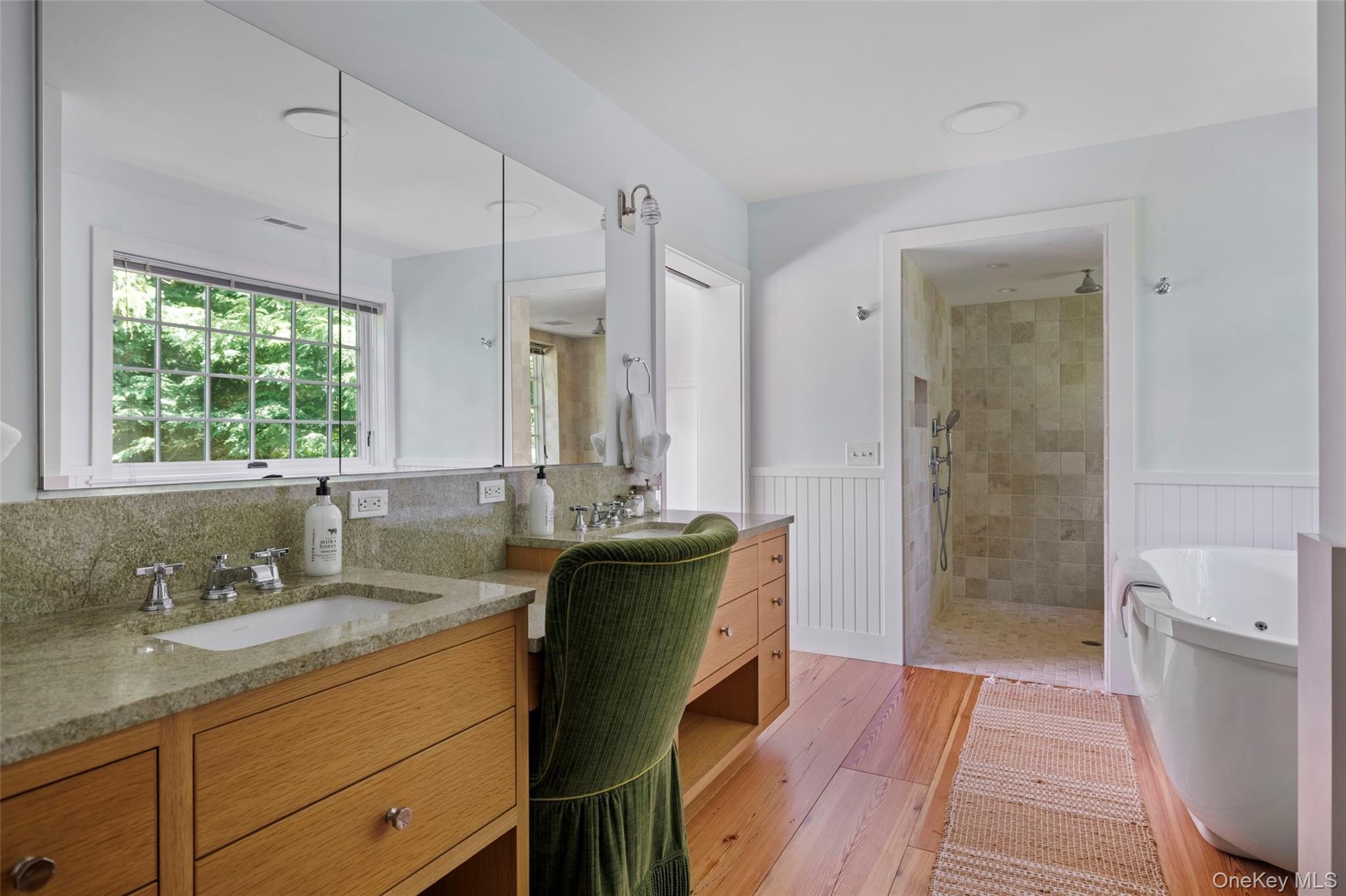 Spa-inspired bathroom with double vanity, oversized walk-in shower, and soaking tub with views over the gardens