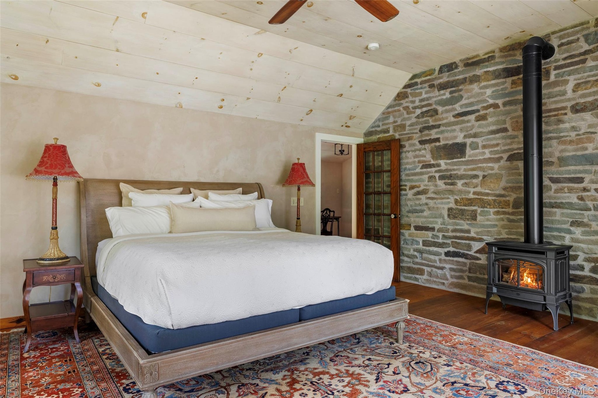 Vaulted ceiling, exposed stone wall, wood stove and adjoining private study