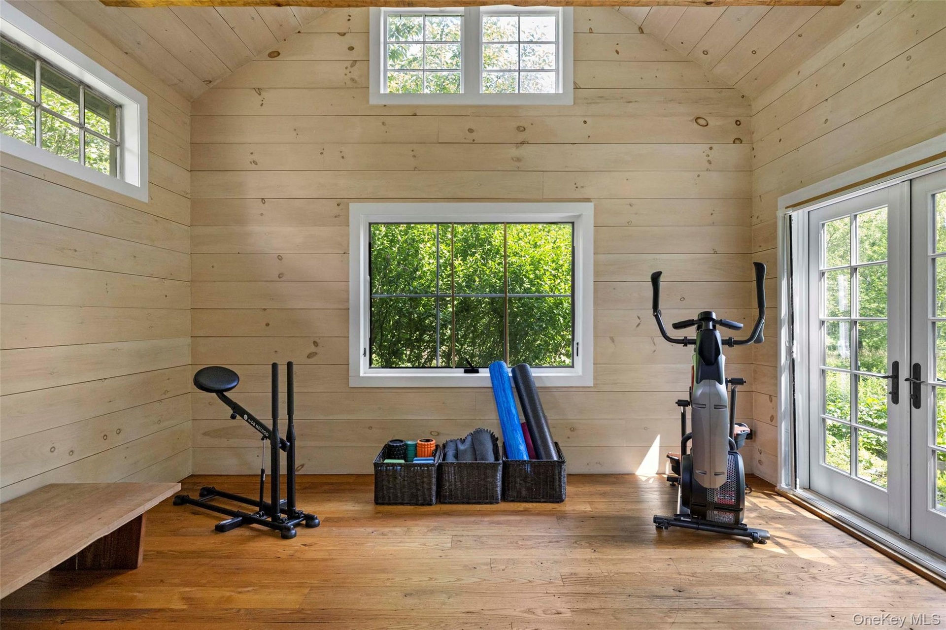 Light-filled wellness studio with vaulted ceilings and French doors opening to the gardens, ideal for yoga, meditation, fitness, or creative pursuits