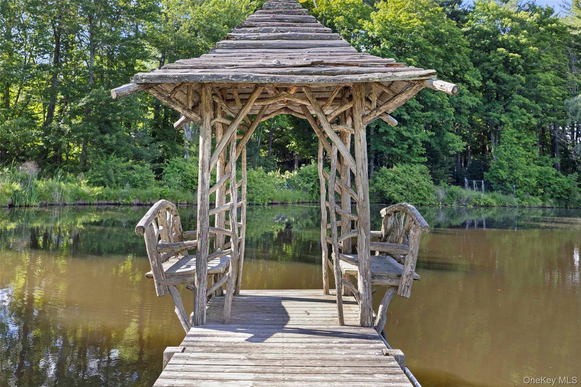 A hand-crafted pond pavilion overlooking the spring-fed pond, offering a secluded place to relax and take in the landscape