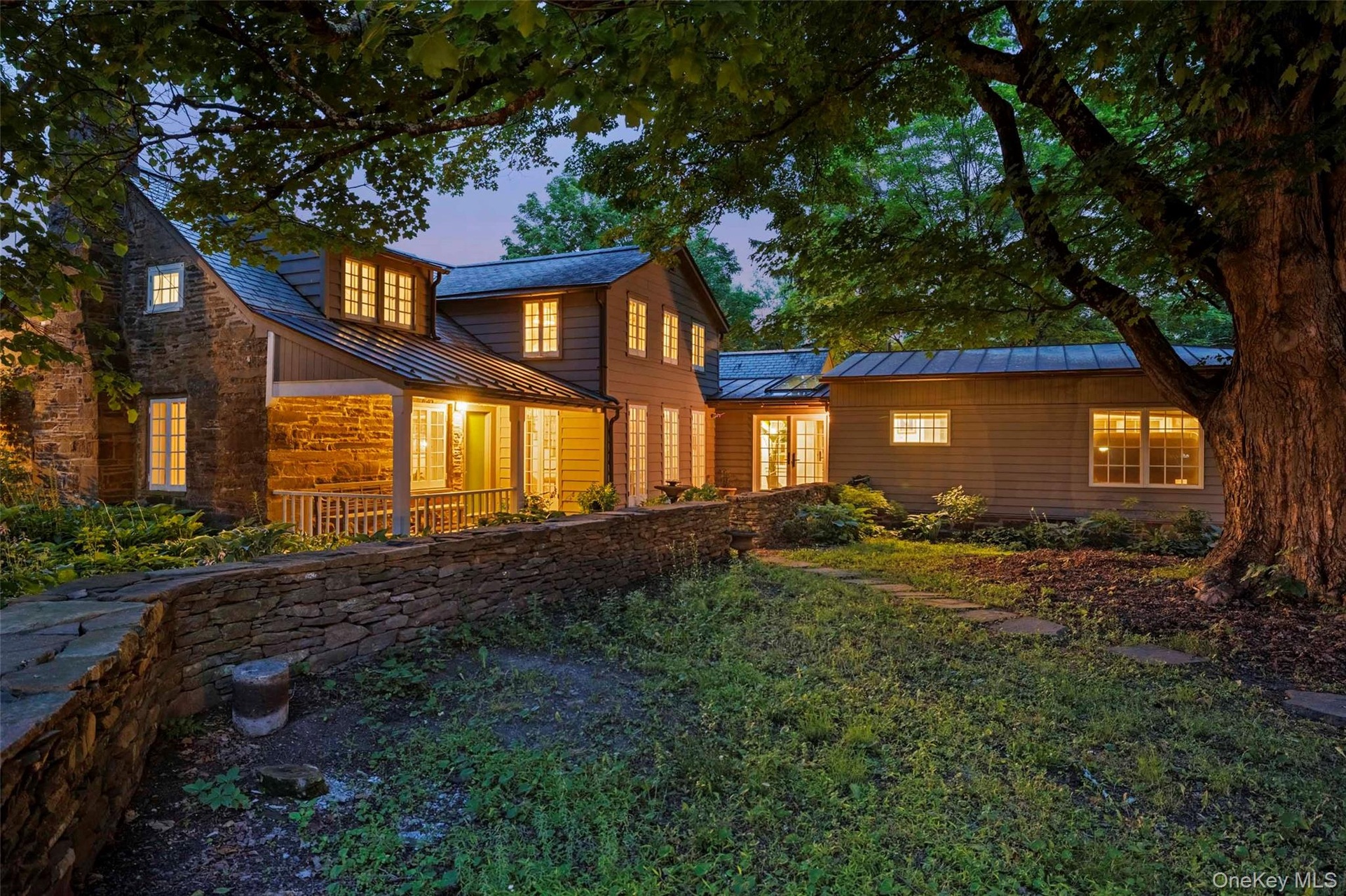 As evening falls, warm light spills from every wing, creating an inviting sense of comfort and timeless country elegance