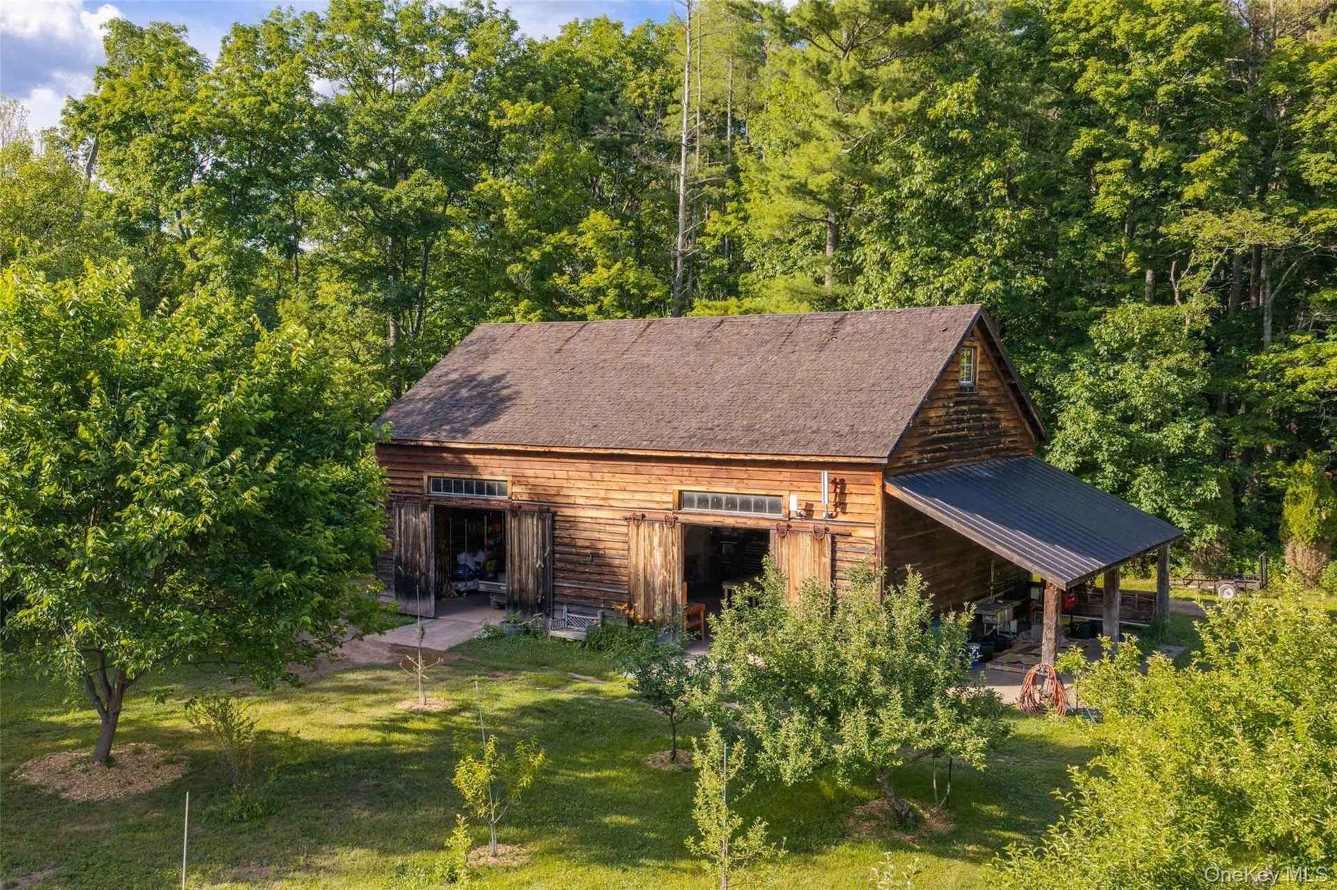 A beautifully restored 19th-century timber-frame barn, relocated from Cairo, New York, supporting the estate’s agricultural and horticultural operatio